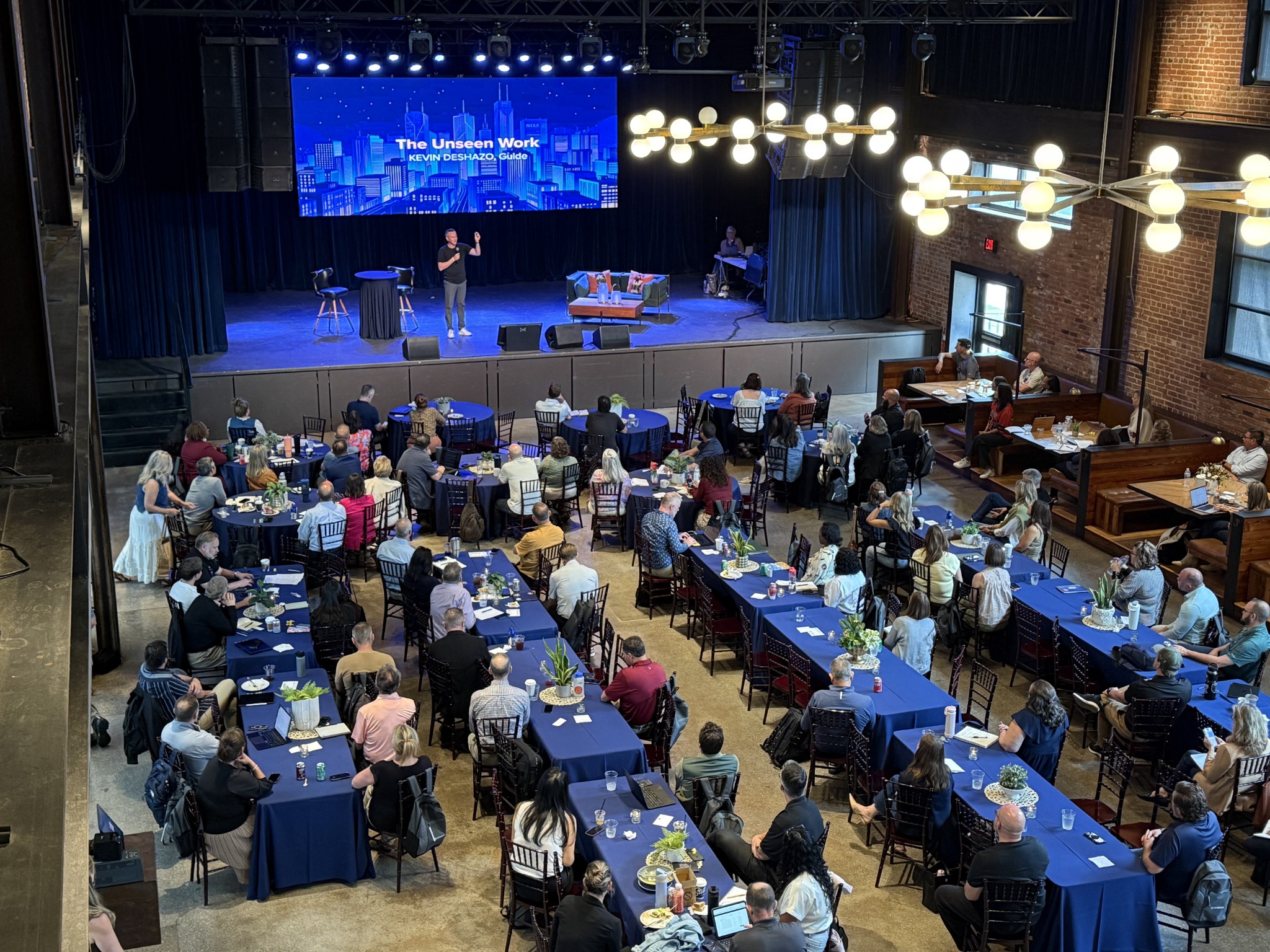 Kevin DeShazo addressing a conference audience at round tables